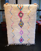 Valkoinen villamatto jossa värikkäät yksityiskohdat