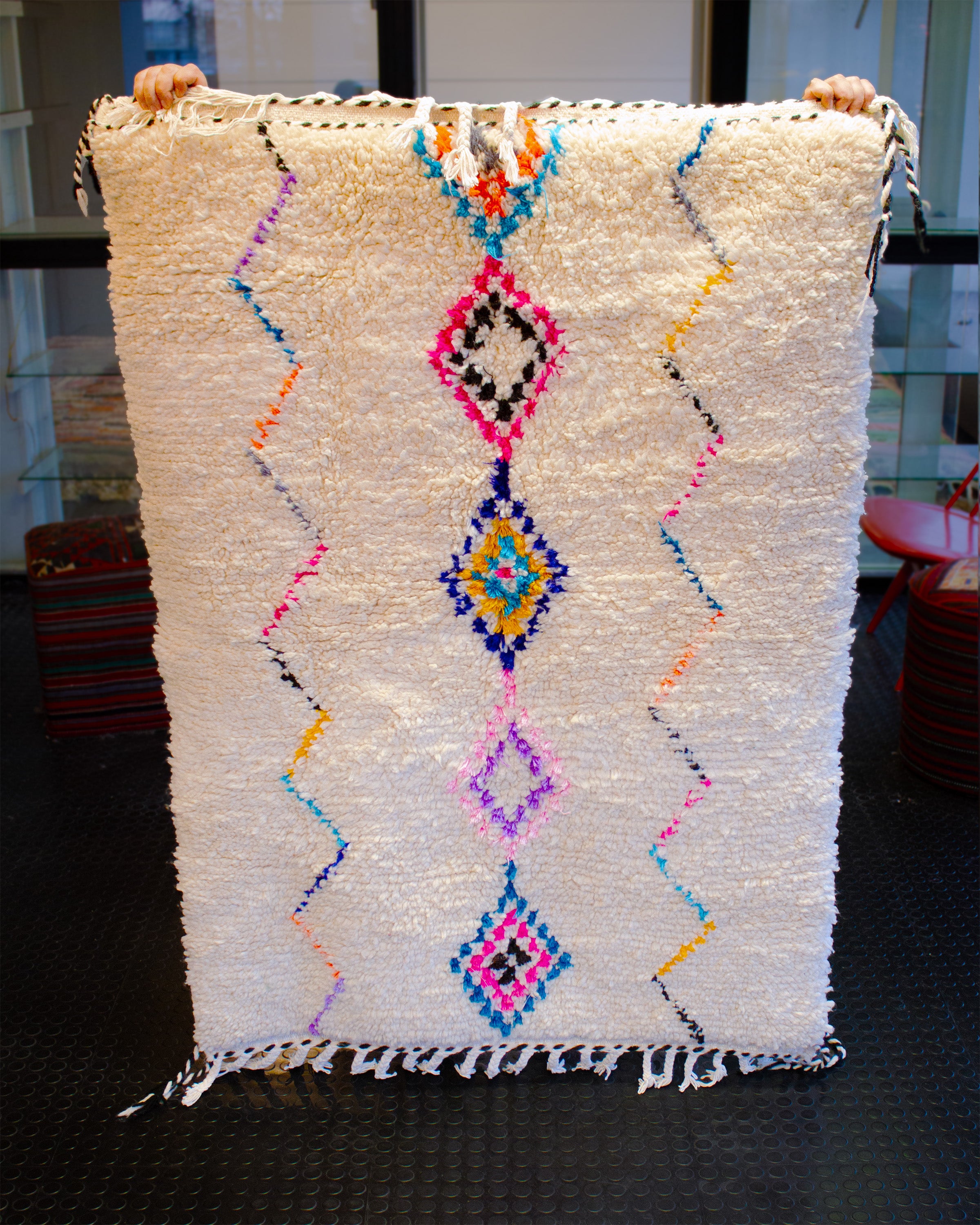 Valkoinen villamatto jossa värikkäät yksityiskohdat